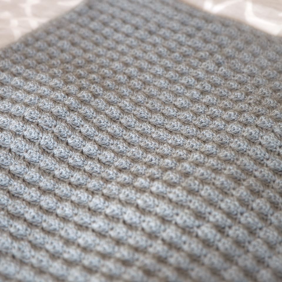 Close pp photo of crochet blanket that uses shell stitches